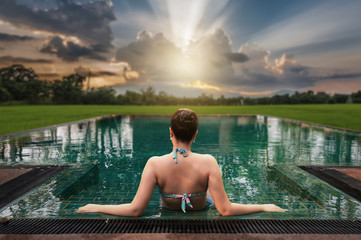 Woman sitting in swimming pool