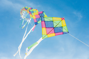 Colorful long line kites flying in blue sky