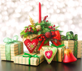 Different Christmas presents with handmade decoration. The branch of a Christmas tree, presents, toys and candle.