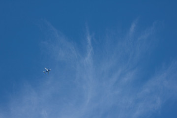 The plane flies in the sky with swirling cloud