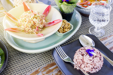 Thai food set menu on outdoor table with orange sun glare