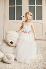 Little princess like a bride standing with a big plush toy