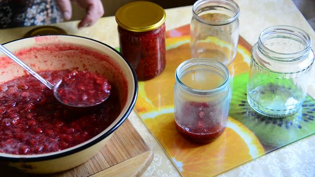 Woman puts handmade Strawberry jam in jar