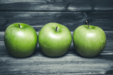 Green apples on grunge gray wooden table.