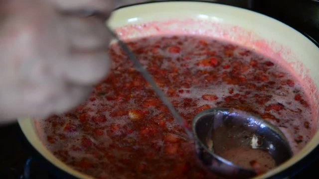 Housewife takes foam with strawberry jam