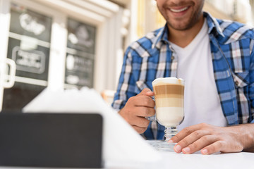 Handsome man relaxing with cup of latte