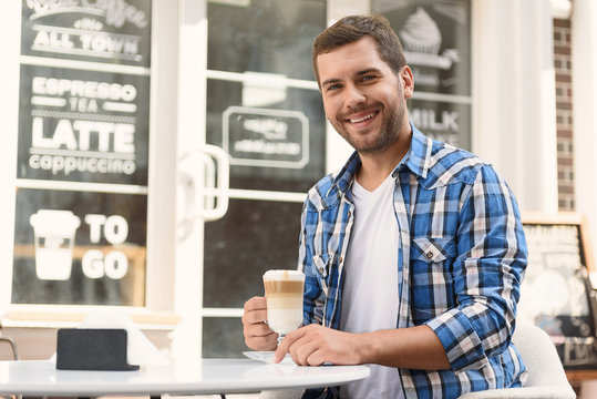 Handsome man relaxing with cup of latte