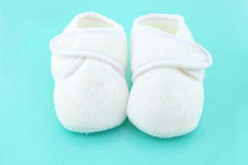 Baby shoes on light blue background