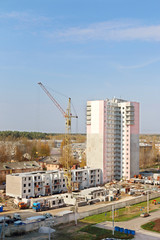 Fototapeta na wymiar Crane on construction site and part of new tall concrete buildin