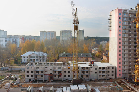 Construction site with cranes and part of concrete panel buildin