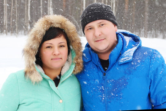 Happy Fat Couple Looks At Camera In Park During Snowfall In Wint