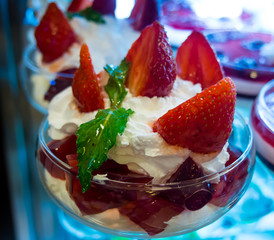 Strawberry with whipped cream in kremanke standing at the counter in the cafe
