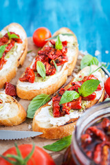 Bruschetta with cream cheese, pesto, fresh basil and sun dried t