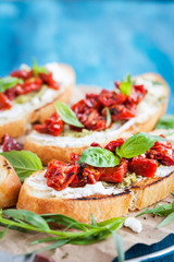 Bruschetta with cream cheese, pesto, fresh basil and sun dried t