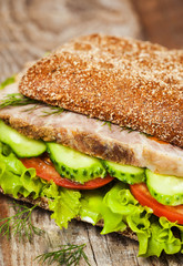 Tasty rye bread sandwiches with roast meat and vegetables