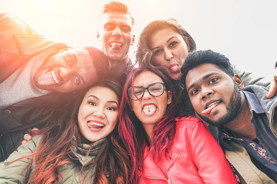 Cheerful friends from different countries and races taking selfie outdoor