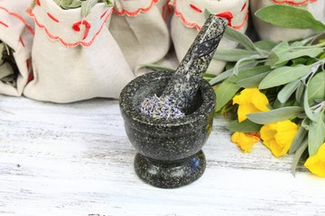 Mortar with lavender, sage herb &  evening primrose flower 