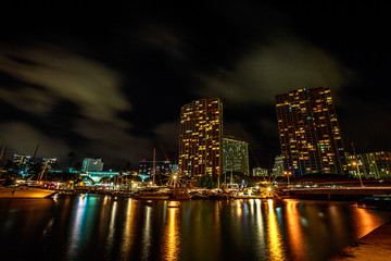 Obraz na płótnie Canvas Beautiful view of Ala Wai Harbor, the largest yacht harbor of Hawaii at night. Honolulu Harbor skyline reflecting in the water. Oahu in Hawaii, United States.