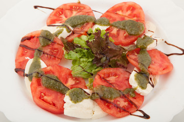 Caprese salad with mozarella cheese, tomatoes and basil