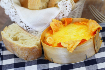 Baked cheese and ciabatta bread on blue and white checkered cloth
