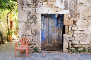 Old painted blue door on the ancient stone wall, Greece