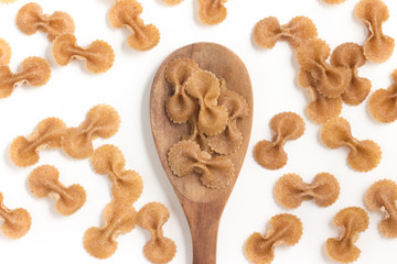 Wholegrain Farfalle into a spoon. wholemeal. Integral.