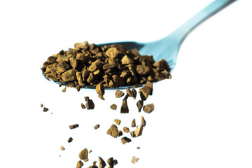 flavored instant coffee is poured into a mug with shiny spoons on  white background