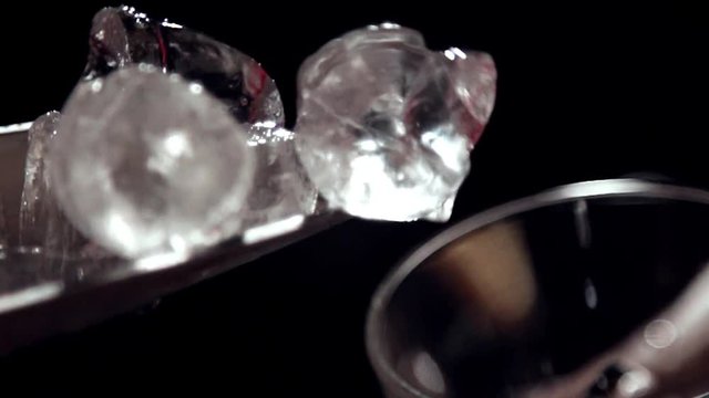 Dropping ice into a wineglass in slow motion