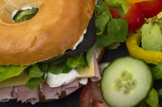 Ham Salad Bagel
Bagel Sliced In Half With Cream Cheese, Rolls Of Fresh Ham And Salad, Served On A Slate Platter