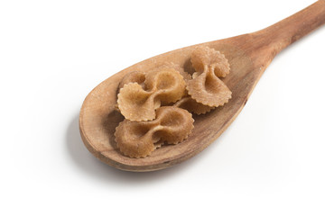 Wholegrain Farfalle into a spoon. wholemeal. Integral.