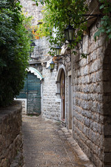 Fototapeta na wymiar The narrow street in the stone fortress with lanterns on a wall