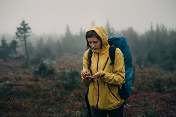 Woman tourist in the rain eats berries