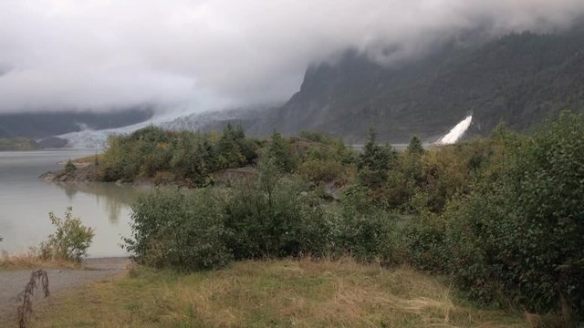 An establishing shot of Mendenhall Glacier near Juneau, Alaska on a foggy day.  	