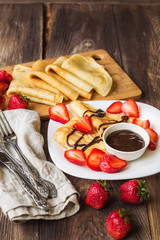 Fresh homemade crepes with strawberries and chocolate sauce