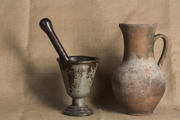 Old vintage rusty mortar and old jar on canvas background