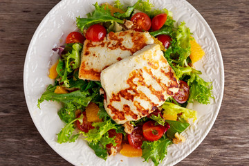 Grilled Halloumi Cheese salad witch orange, tomatoes and lettuce. healthy food