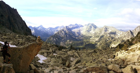 Climber taking a picture of a rock signal showing the way to a summit with wonderful valley and mountains on background, Pyrenees Mountains, Catalonia, Spain.