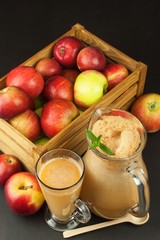 Fresh pressed apple juice unfiltered. Apple juice and apples on wooden table. A healthy juice for athletes. Autumn apple harvest.

