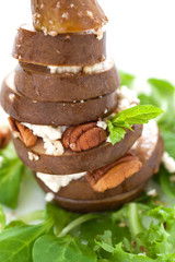 Baked pear with cheese, nuts and honey on a salad, closeup, selective focus