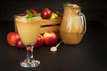 Fresh pressed apple juice unfiltered. Apple juice and apples on wooden table. A healthy juice for athletes. Autumn apple harvest.
