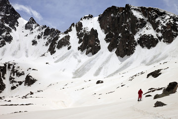 Hiker in snow mountain with trace from avalanches at sun spring