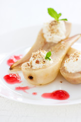 Homemade poached pear with whipped cream, nuts, mint, honey and jam, closeup