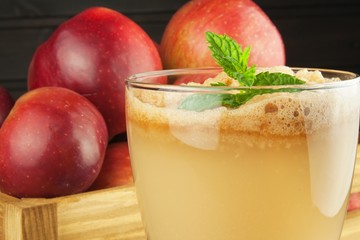 Fresh pressed apple juice unfiltered. Apple juice and apples on wooden table. A healthy juice for athletes. Autumn apple harvest.
