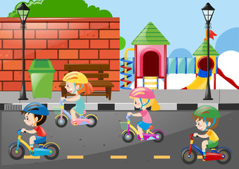 Obraz na płótnie Canvas Four kids cycling on the road