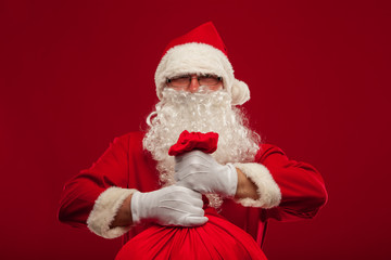 santa claus with big bag on shoulder glasses  red background