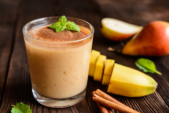 Fresh smoothie with banana, pear and cinnamon in a glass jar