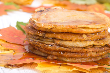 pancakes with maple syrup on autumn multicolored leaves