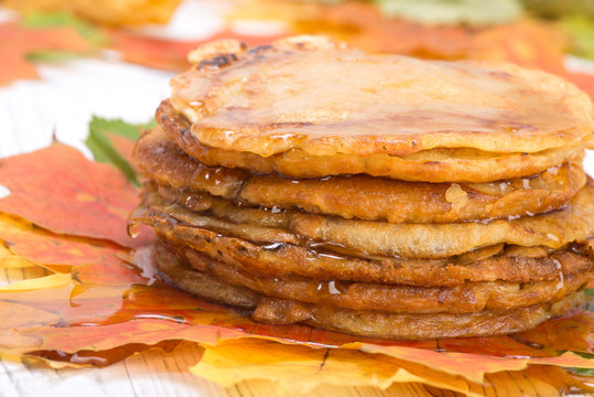 pancakes with maple syrup on autumn multicolored leaves