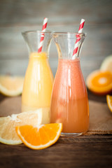 Fresh juice and smoothies with fruits on wooden background