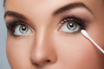 Fototapeta premium Woman with a cotton swab beside her eye